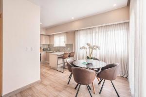 a dining room with a table and chairs and a kitchen at Fully Serviced Apartment at Regatta Living - 3B in Santo Domingo