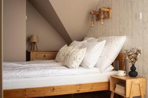 a bedroom with a bed with white sheets and pillows at Apartament Sarenka in Rogożnik