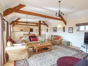 a living room with couches and a table at Tan Twr - Chellow Cottage in Dwyran