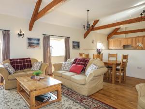 a living room with two couches and a table at Tan Twr - Chellow Cottage in Dwyran