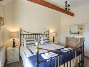 a bedroom with a bed and two lamps and a mirror at Tan Twr - Chellow Cottage in Dwyran