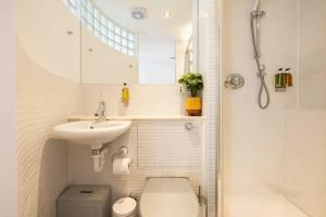 a bathroom with a toilet and a sink and a shower at Central Soho Warehouse Loft with Concierge in London