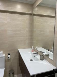 a bathroom with a white sink and a mirror at Apartamento en Getxo. Cercano al puerto viejo in Getxo