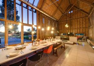 a dining room with a long table in a barn at Grand Suffolk Barn Conversion in Chelsworth