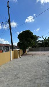 a brick courtyard with a yellow wall and a telephone pole at Villa Rubia Bonaire in Kralendijk