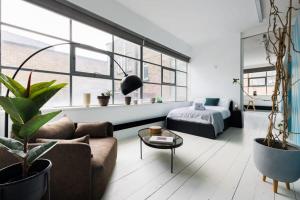 Spacious & Bright Loft Apartment - Shoreditch في لندن: غرفة معيشة مع أريكة وطاولة