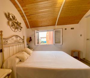 a bedroom with a large white bed with a window at Casa en el MAR in Benicarló