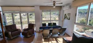 a living room with a desk and chairs and windows at APARTAMENTO VISTASALRIO ADRIANA,Montanejos in Montanejos