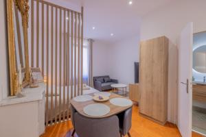 a living room with a table and chairs in a room at Appartement de Charme in Aix-en-Provence +5 photos