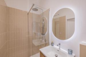bagno con doccia, lavandino e specchio di Appartement de Charme ad Aix en Provence