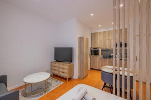 un soggiorno con TV, tavolo e sedie di Appartement de Charme ad Aix en Provence
