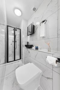 a white bathroom with a toilet and a sink at Stylish One Bedroom Flat - Sleeps 4 - Near Primrose Hill, Lord's Cricket Ground, Camden Market - Finchley Road Station - Central London NW3 in London