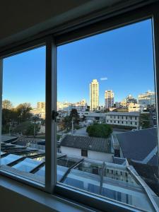 a view of a city from a window at Apartamento NOVO no centro/Via Gastronômica in Lages