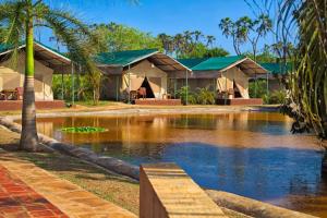 a resort with a pond in front of it at BoraBora Wildlife park and Luxury Tented Safari Camp Diani in Diani Beach