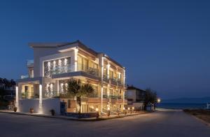 a large white building with lights on at Ikies Apollon Boutique Hotel in Sarti