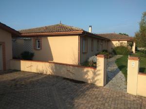 a house with a fence and a driveway at Studio T1 paisible dans villa avec bassin naturel in Saint-Pierre-de-Lages