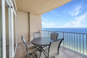 a table and chairs on a balcony with the ocean at Phoenix Gulf Shores Unit 1702 in Gulf Shores