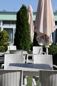 een tafel en stoelen met een parasol erop bij Meridiana Hotel in Novi Sad
