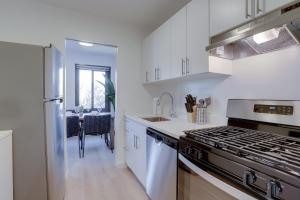 uma cozinha com armários brancos e um forno com placa de fogão em Amazing studio front the Barton Park at Clarendon em Arlington
