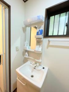 La salle de bains est pourvue d'un lavabo et d'un miroir. dans l'établissement Ichishuku Ikkei Issei-Chiba Prefecture Yotsukaido - Vacation STAY 16242, à Yotsukaidō