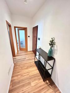 a hallway with a table with a vase on it at Soleo guesthouse in Monza +11 photos