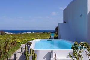 a swimming pool in front of a house with the ocean at MyBozer Twin Villas Heated Private pools All Year in Foinikiá