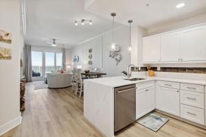 a kitchen with white cabinets and a living room at 58 Ocean Place - Luxury 2BR 2Ba oceanfront condo right next door to the Ritz Carlton in Fernandina Beach