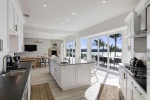 a kitchen with white cabinets and a view of the ocean at The Narrows- Stunning Bayfront Villa on Captiva in Captiva +36 photos