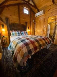 1 dormitorio con 1 cama en una cabaña de madera en Disarmingly Cozy 1BR Cabin, en Henderson