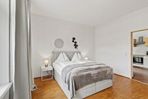 a white bedroom with a bed and a mirror at Dein Zuhause fern von Zuhause in Donawitz