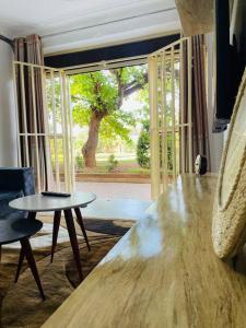 a living room with a table and a window at Serenity in style in Kampala