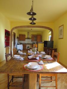 un comedor con una mesa de madera con platos. en La Superba Ca' Zeneize, en Foiano della Chiana