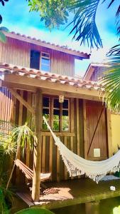 een huis met een hangmat ervoor bij Recanto das Bromélias Chalés in Guarda do Embaú