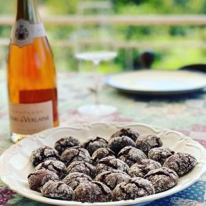 a plate of chocolate donuts on a table with a bottle of wine at Agrirelais La Bolla in Agliè
