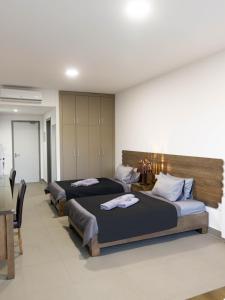 a row of four beds in a room at Grey escape apartments in Qalḩāt