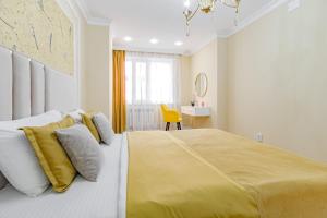 um quarto com uma cama grande e um cobertor amarelo em Amor de Astaná, ЖК Симфония, 3 комнатная em Astana