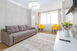 uma sala de estar com um sofá e cadeiras amarelas em Amor de Astaná, ЖК Симфония, 3 комнатная em Astana