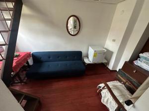 ein Wohnzimmer mit einem blauen Sofa und einem Spiegel in der Unterkunft Cabaña con excelente ubicación y zona verde. in Iza