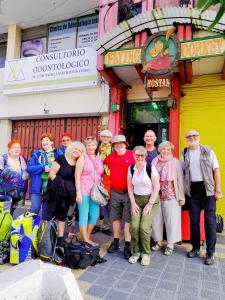 un grupo de personas de pie en frente de un edificio en Flying Donkey, en Otavalo