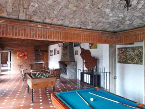 a room with a pool table and a fireplace at Cabaña de bosque con alberca in Santa Clara de Juárez