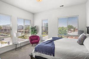 sypialnia z łóżkiem, czerwonym krzesłem i oknami w obiekcie Townhome W Roof Patio Hot Tub Near Broncos Field w mieście Denver