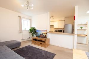 a living room with a couch and a tv at OPP Exeter - Lovely 2 bed offering BIG SAVINGS booking 7 days or more! in Exeter