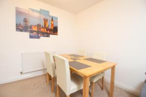 a dining room with a wooden table and chairs at OPP Exeter - Lovely 2 bed offering BIG SAVINGS booking 7 days or more! in Exeter