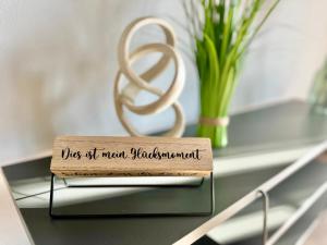 ein Holzschild auf einem Tisch neben einer Vase in der Unterkunft ElbOase - Radfahrer willkommen! in Dresden