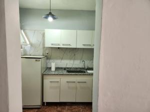 cocina con armarios blancos y nevera blanca en DEPARTAMENTO CENTRO en Zapala