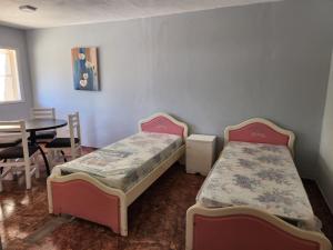 two beds in a room with a table and a tableablishthritisthritisthritisthritis at DEPARTAMENTO CENTRO in Zapala