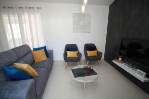 アルブフェイラにあるApartamento A Palmeiraのリビングルーム(ソファ、椅子2脚付)