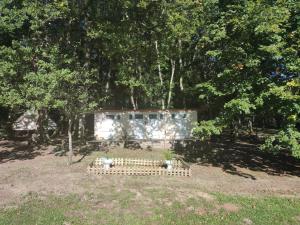 un banco en medio de un parque con árboles en Camping sous les belles etoiles, en Peyrilhac