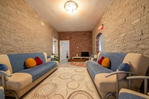 a living room with a blue couch and a brick wall at Kapadokya Hatice Ana Tatil Evi in Urgup