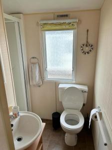 uma pequena casa de banho com WC e lavatório em 519 Family Caravan at Golden Gate Holiday Centre, Sleeps 6 em Abergele